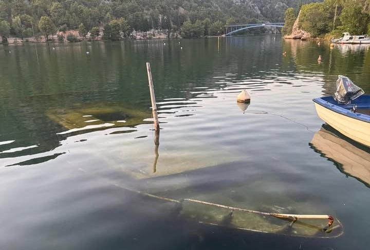Pola u rijeci, pola u zaboravu: Potopljena brodica već dvije godine na ulazu u NP Krka, nije jasno u čijoj je nadležnosti