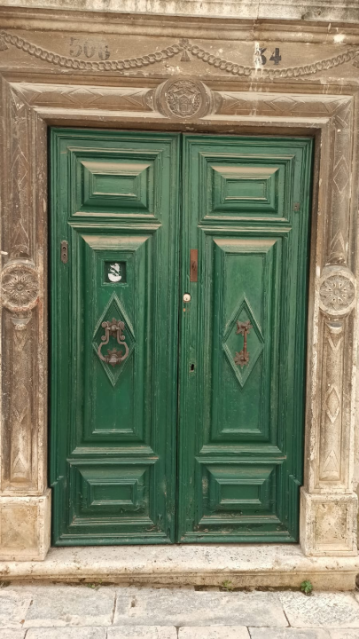 Vjerna kopija otuđenog kucala baroknog stila postavljena na drvene vratnice u Kačićevoj ulici 