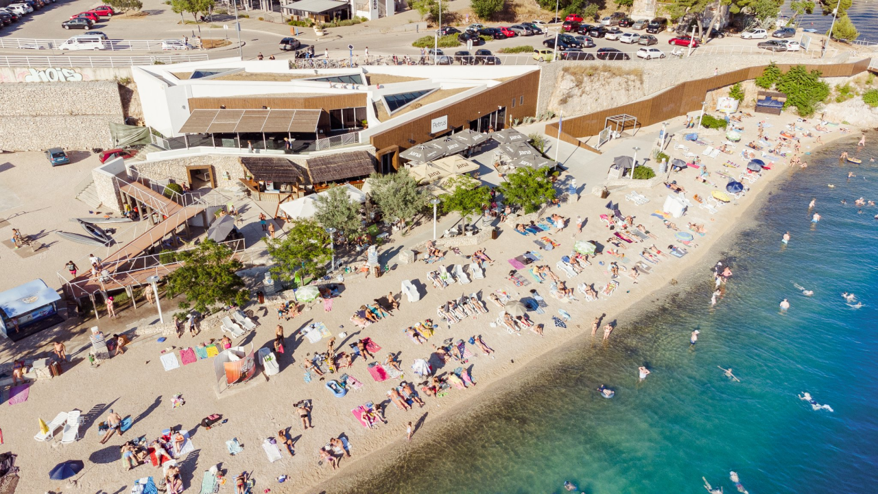 Zaigrajte odbojku na pijesku na plaži Banj, a predah potražite u Petrusu!